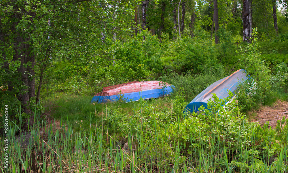 Small plastic boats lying upside down in the grass. Small plastic boats lying upside down in the grass.