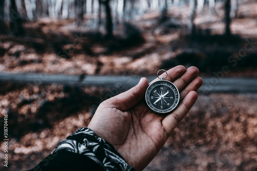 The compass in my hand is in the background FOREST, Compass, navigational compass, travel compass, lost compass,
