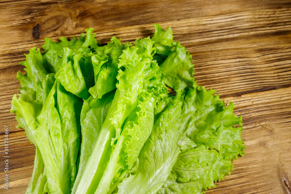 Fresh green lettuce leaves on wooden table. Top view Fresh green lettuce leaves on wooden table. Top view