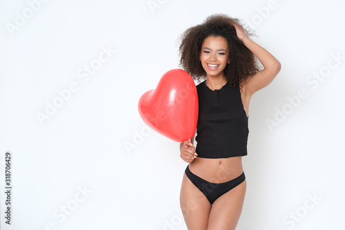 Pretty, young and full of energy afro-amercian model with heart shaped balloon. © forma82