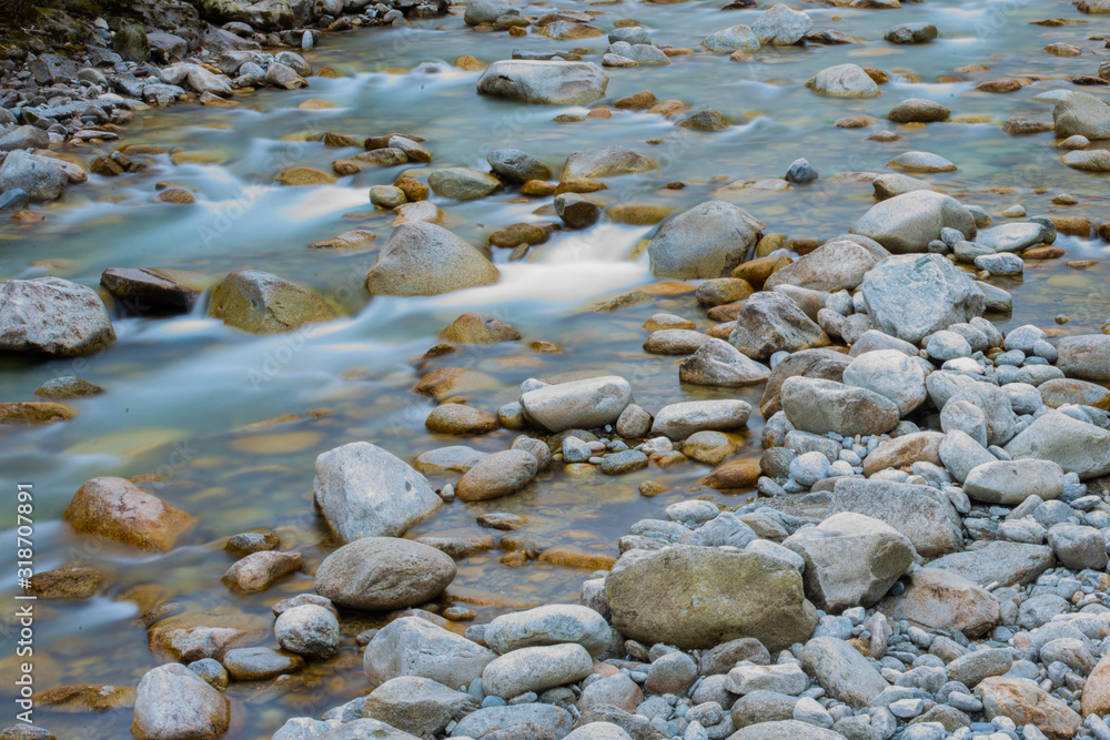 Obraz premium river flows among stones timelapse