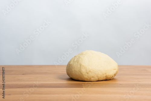 Wheat dough rising on a wooden table
