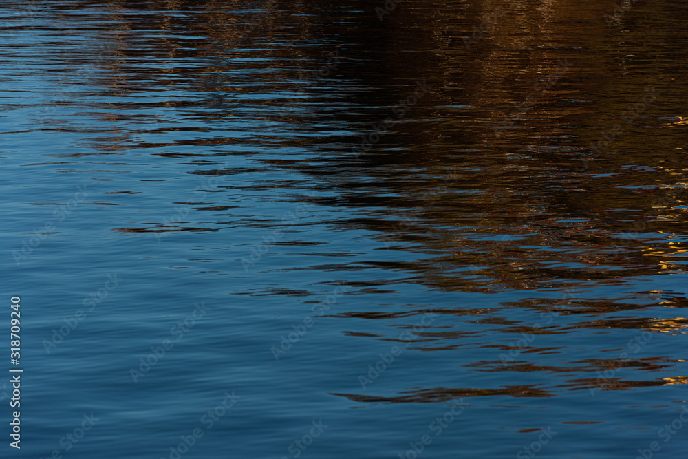 Water with small waves. Reflections of blue sky and buildings. Water with small waves. Reflections of blue sky and buildings.