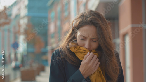Face young woman stand sneezing coughs feel sick at outdoor fever cold allergy city beautiful disease female nose lady runny tissue air pollution adult illness district slow motion photo