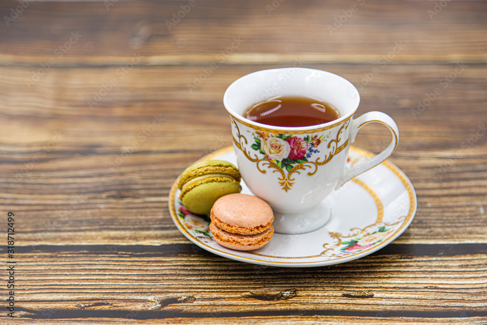 Cup of tea with macaroons on wooden background Cup of tea with macaroons on wooden background