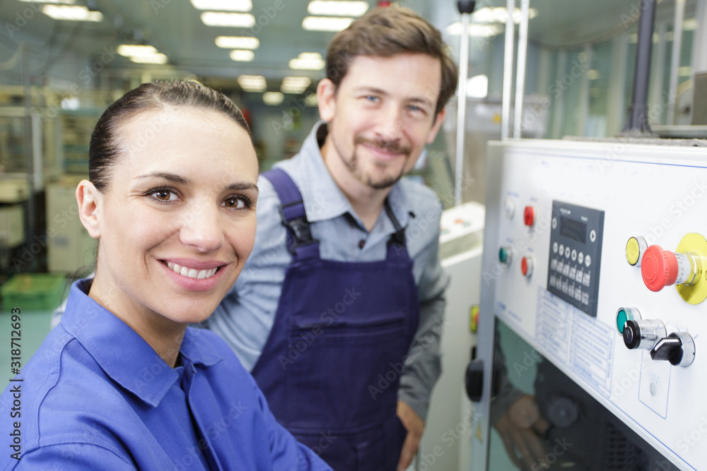 engineer and apprentice examining a machine in factory engineer and apprentice examining a machine in factory