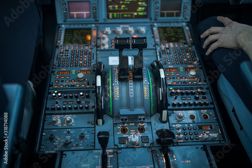 Pilot's hand dialing in flight values in  a commercial airliner airplane flight cockpit during takeoff