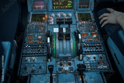 Pilot's hand dialing in flight values in  a commercial airliner airplane flight cockpit during takeoff photo