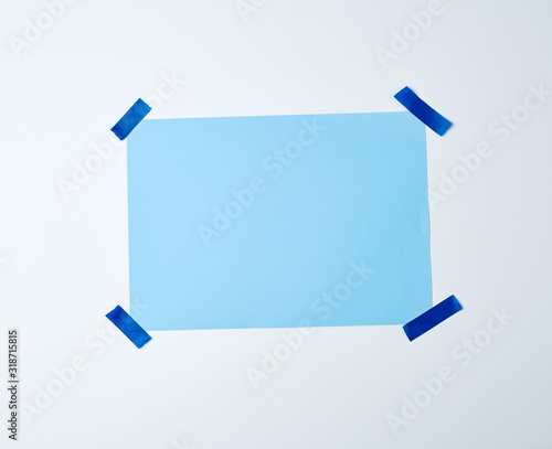 blank blue sheet of paper stuck with blue sticky tape