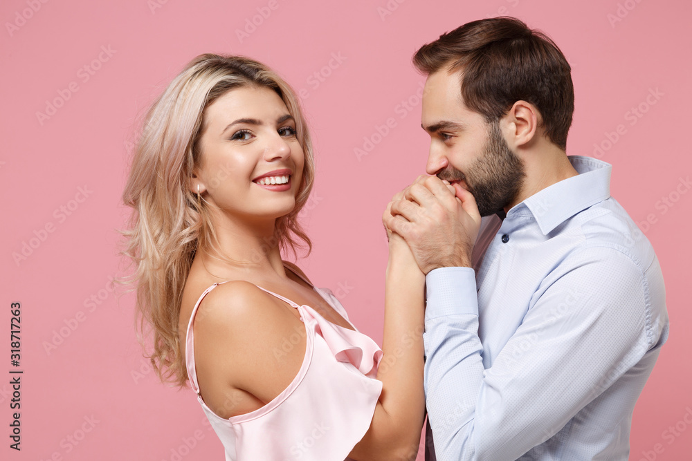 Beautiful young couple two guy girl in party outfit celebrating posing isolated on pastel pink wall background. People lifestyle Valentine's Day Women's Day birthday holiday concept. Kissing hands. Beautiful young couple two guy girl in party outfit celebrating posing isolated on pastel pink wall background. People lifestyle Valentine's Day Women's Day birthday holiday concept. Kissing hands.