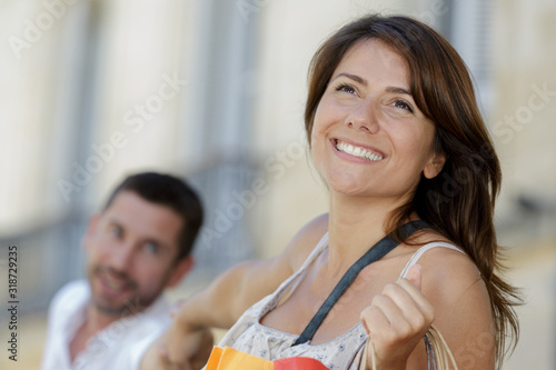 girlfriend pulling her boyfriend to go shopping