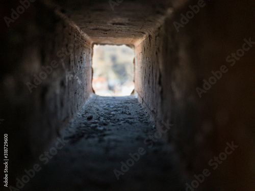 Look through the inside of rectangle brick hole in different perspective and affinities , sunlight is seeping in