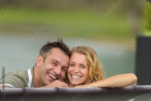 portrait of happy couple looking over top of hammock