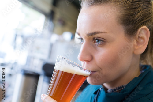 close-up of female brewer testing beer