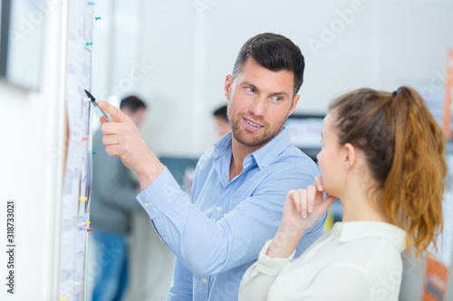 man pointing at information on the wall