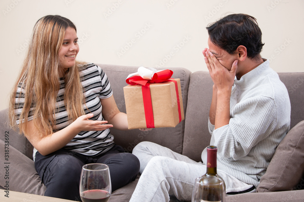 Cute young latin couple exchanging gift for valentines day Cute young latin couple exchanging gift for valentines day