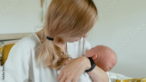 Caucasian mom calms a crying baby while holding in her arms