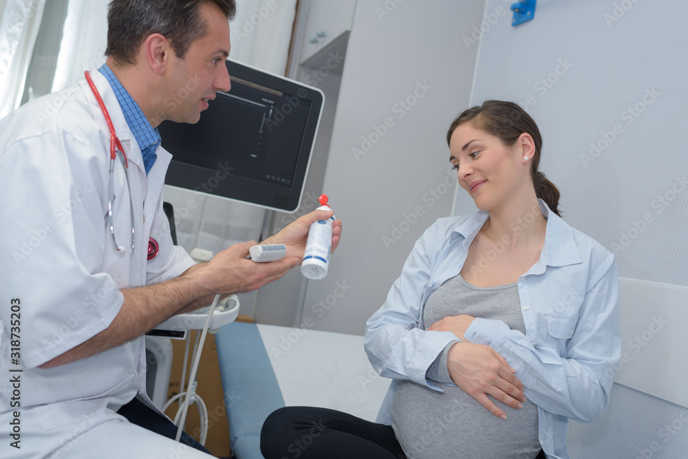 Obraz premium doctor showing lubricant gel to reluctant pregnant woman