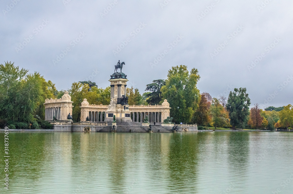monument to King Alfonso XII, featuring a semicircular colonnade and an equestrian statue of the monarch on the top of a tall central core near the lake in Parque del Buen Retiro . Madrid, Spain