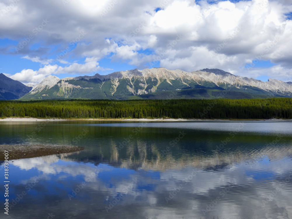 Mountains and clouds reflected in serene Lower Kananaskis Lake