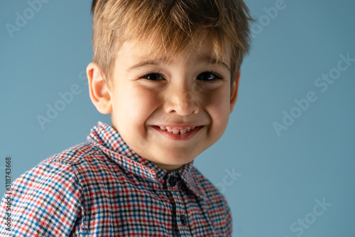 Portrait of small boy caucasian kid child wearing shirt brown hair studio shot looking to the camera smiling smile