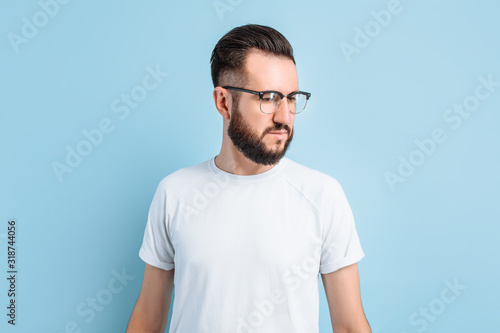 Young stylish hipster in glasses on a blue background