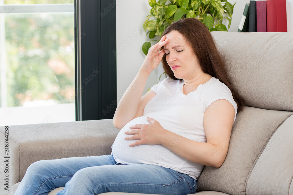 Pregnant woman suffering headache at home Pregnant woman suffering headache at home