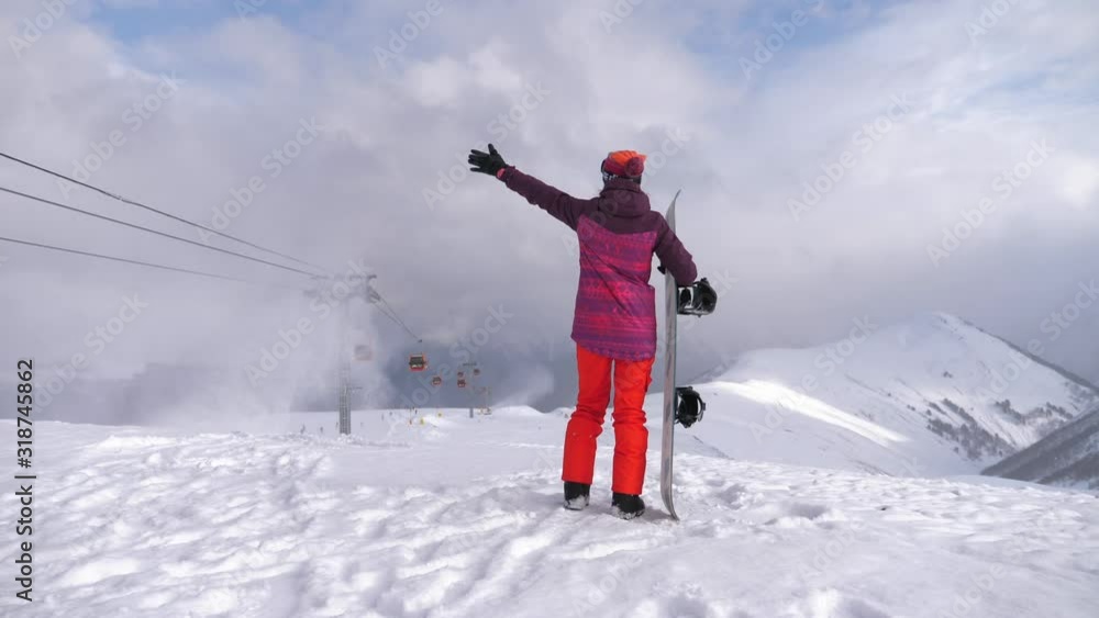 Girl snowboarder with snowboard on mountain top on ski resort. Winter sports and winter vacation concept. Sunny winter day in ski resort. Girl snowboarder with snowboard on mountain top on ski resort. Winter sports and winter vacation concept. Sunny winter day in ski resort.