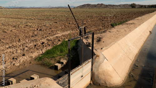 Closed irrigation sluice gate  and canal in farmers field - Arizona