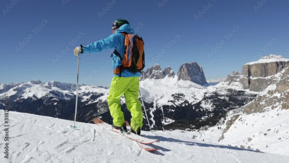 Downhill skier inspecting slope, Dolomites, Italy Downhill skier inspecting slope, Dolomites, Italy