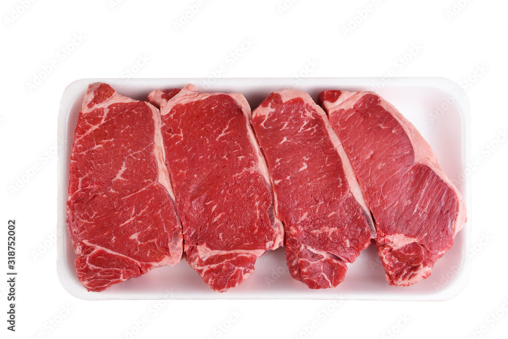 Four Boneless Beef Loin New York Steaks in a styrofoam tray isolated on white.