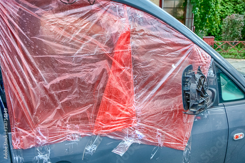 Car With Broken Door Window. Taped with Protective Film Before Repairing. photo