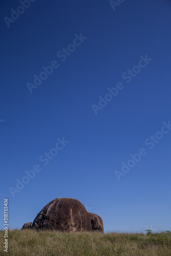 Iconic rock green grass blue sky