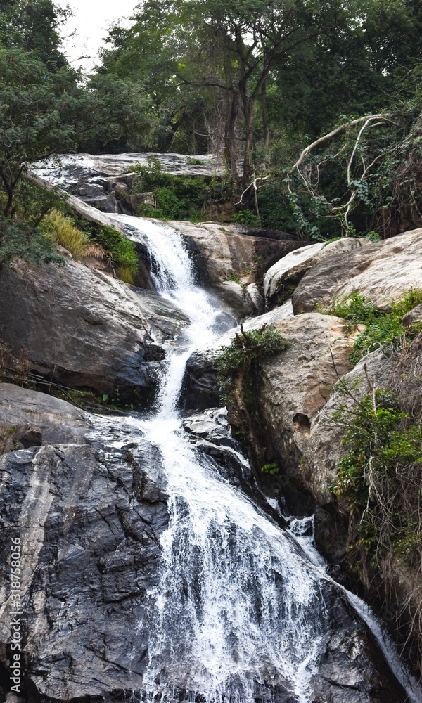 Fototapeta premium Monkey falls in India, stream of water flows through the steep slopes of rocks