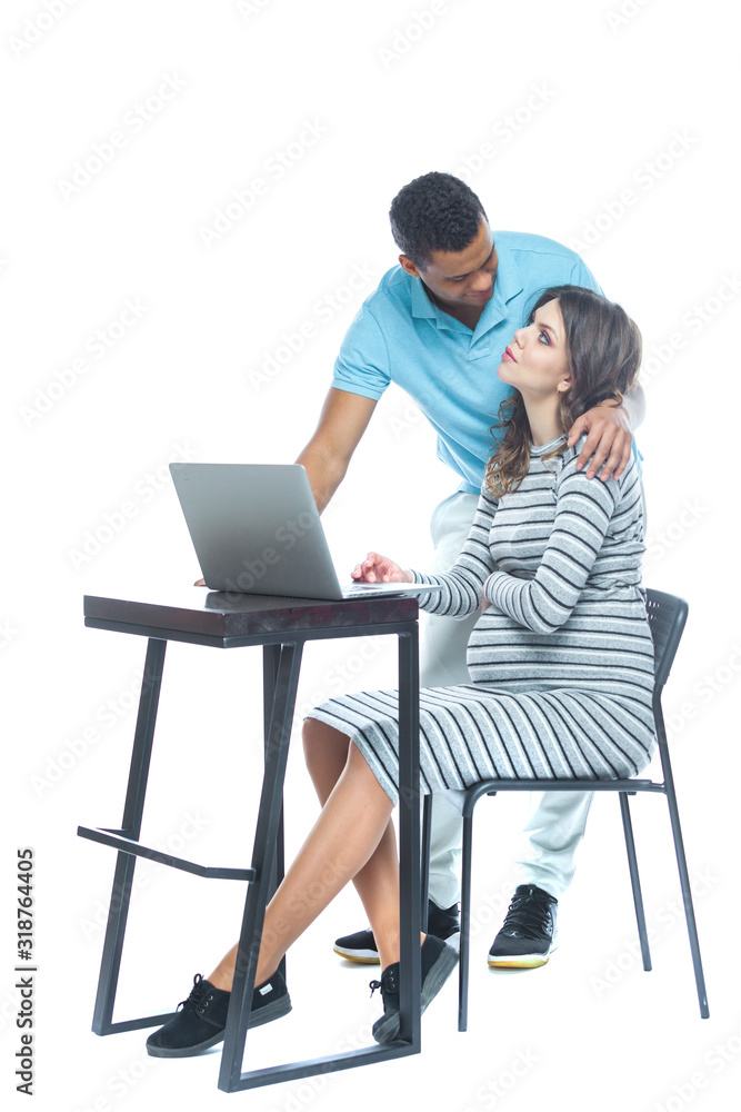 Portrait of a lovely young pregnant couple sitting on a couch with laptop computer. Black man and white woman. Portrait of a lovely young pregnant couple sitting on a couch with laptop computer. Black man and white woman.