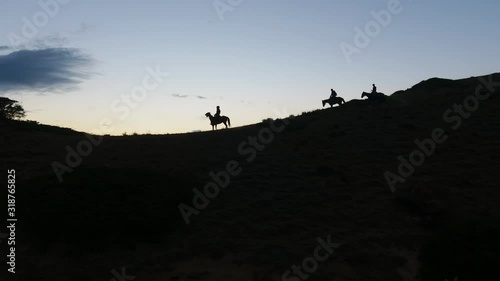 Aerial Drone Shot of Beautiful Mountain Ridge with Silhouetted Horseback Riders at Sunset