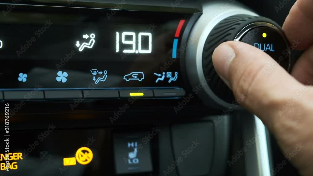 the driver sets the air conditioning heating in the car to maximum heat. adjusting the AC air conditioning system. Dual climate control in the car. the driver sets the air conditioning heating in the car to maximum heat. adjusting the AC air conditioning system. Dual climate control in the car.