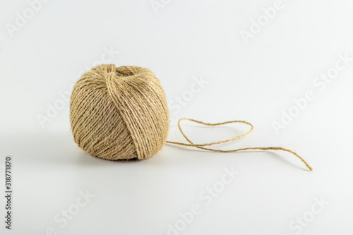 Jute twine with heart shape, isolated on white background. Copy space for text. Skein of natural jute thread.