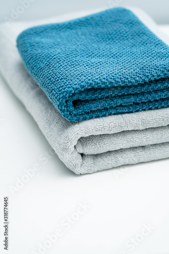 Two lovers towels and bath towels on a white table. Blue towels gray towels bath towels © Liu Lei