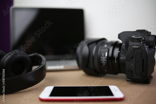 Audio, video and photography business office with equipment such as laptop, mobile phone, headphones and camera with photographic accessories