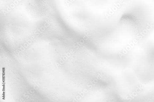 White foam texture close up background. Soapy substance with bubbles backdrop. Creamy grainy macro. Shower gel, washing liquid smears wallpaper. Cosmetic product foamy smudges top view photo