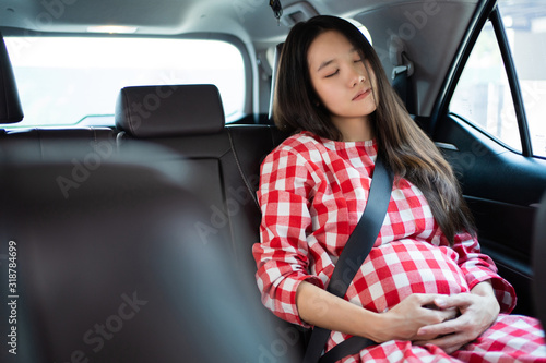 Pregnant asian women she is sleeping in the car.