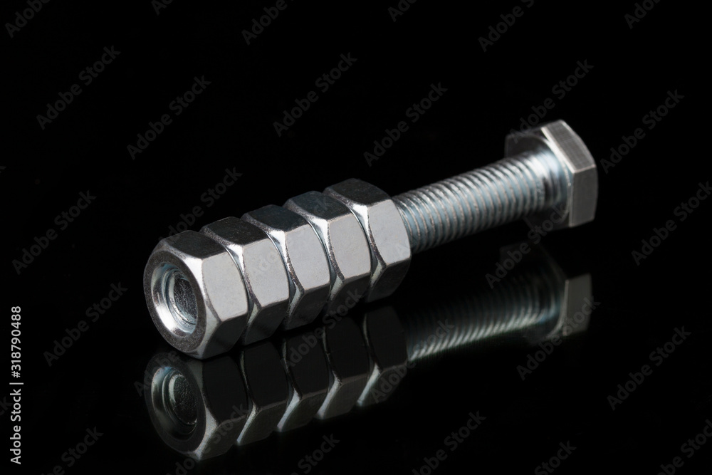 Metal bolt and nuts on black background Metal bolt and nuts on black background