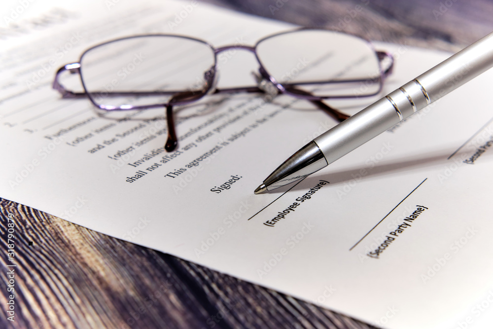 Contract sheet with glasses and a pen on a wooden background Contract sheet with glasses and a pen on a wooden background