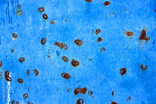 Abstract background of peeling white paint on a blue wall, rust on a cold wall