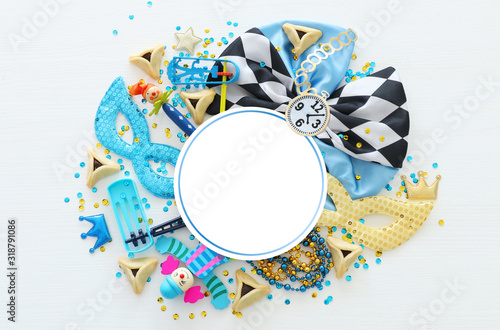 Purim celebration concept (jewish carnival holiday) over white wooden background. Top view, Flat lay