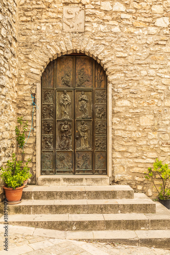 Fototapeta Naklejka Na Ścianę i Meble -  Italy, Sicily, Province of Palermo, Prizzi. Carved wooden door and a stone wall in Prizzi.