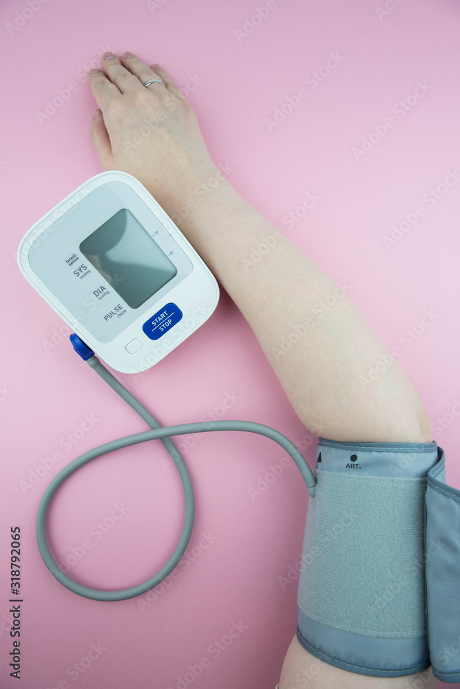 Measurement of blood pressure using a medical electronic automatic tonometer. A blood pressure monitor measures the pressure on a woman Measurement of blood pressure using a medical electronic automatic tonometer. A blood pressure monitor measures the pressure on a woman