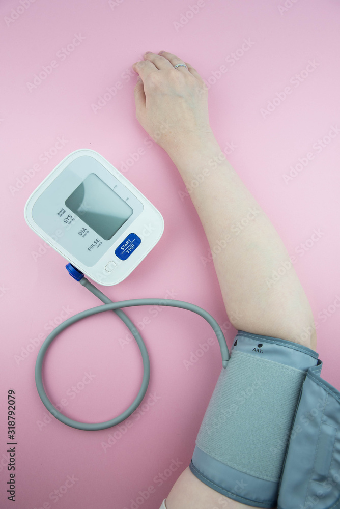 Measurement of blood pressure using a medical electronic automatic tonometer. A blood pressure monitor measures the pressure on a woman Measurement of blood pressure using a medical electronic automatic tonometer. A blood pressure monitor measures the pressure on a woman