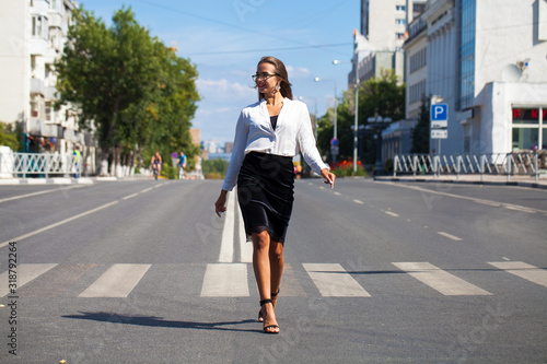 Business brunette woman walking in summer street